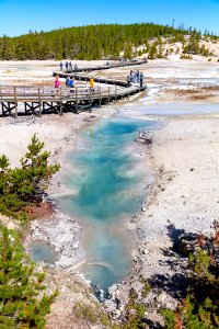 People walking the boardwalks next to Sunday Geyser and pool