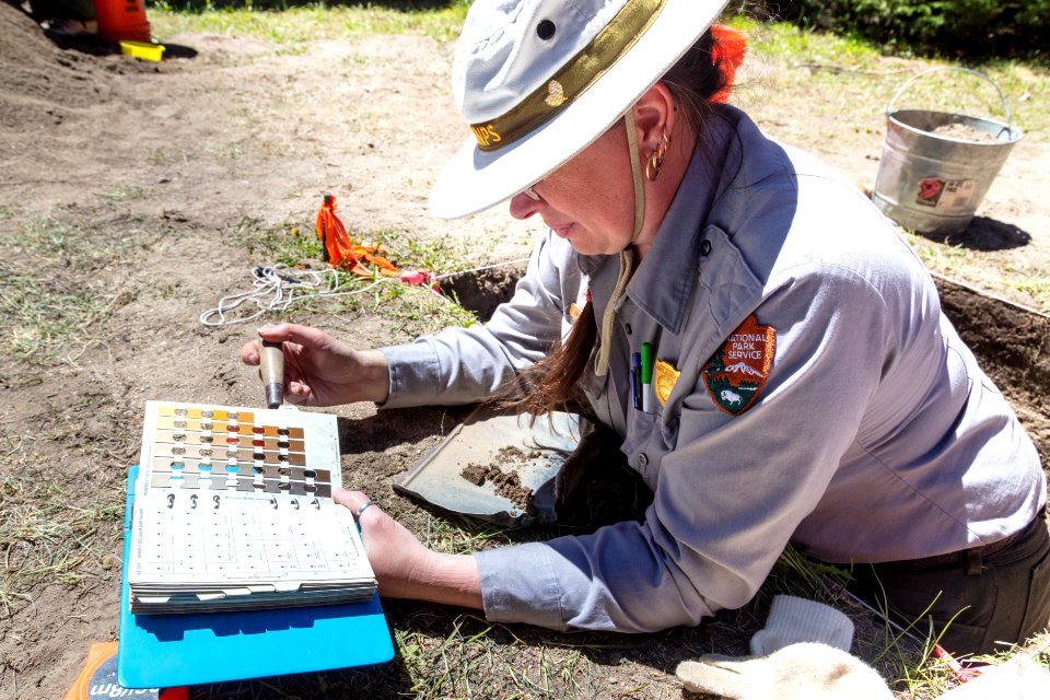 Park Archaeologist Beth Horton examine soil color