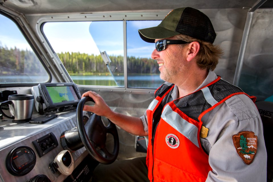 A ranger pilots the NPS Workskiff II on Yellowstone Lake