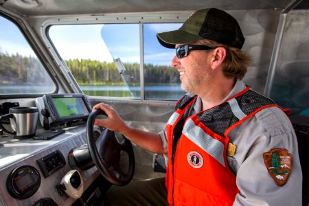 A ranger pilots the NPS Workskiff II on Yellowstone Lake