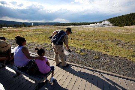 Volunteer picks up garbage near Old Faithful