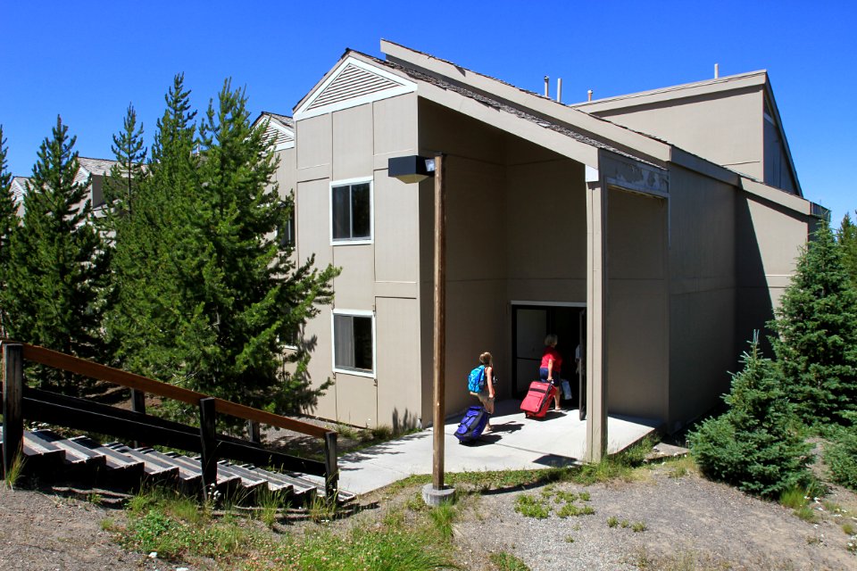 Grant Village, visitors moving luggage into a building
