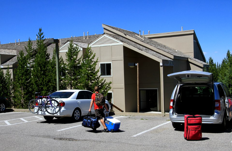 Grant Village, a visitor moving luggage into a building