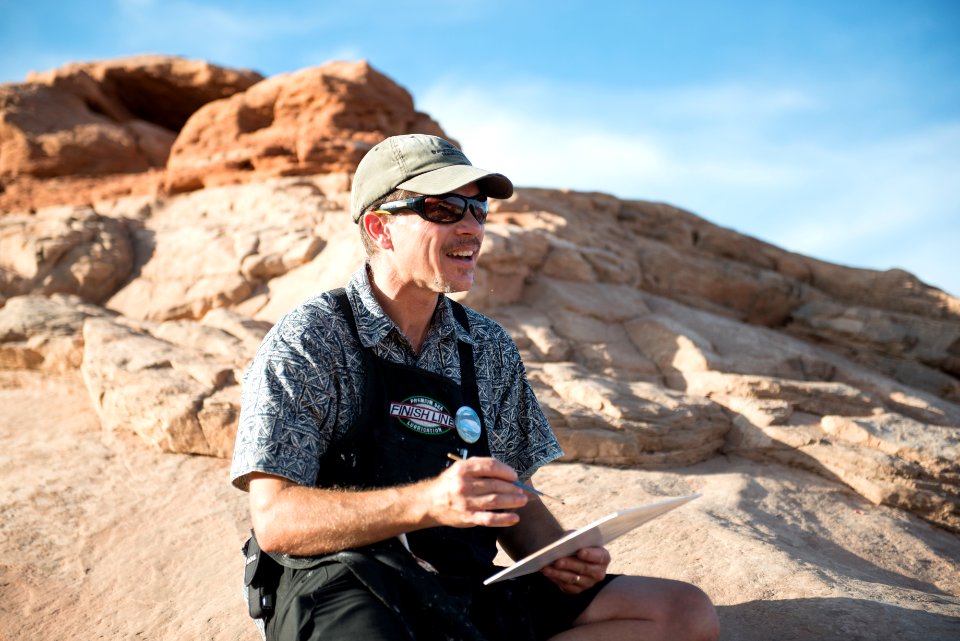 Community Artist Anthony Lott paints at Mesa Arch