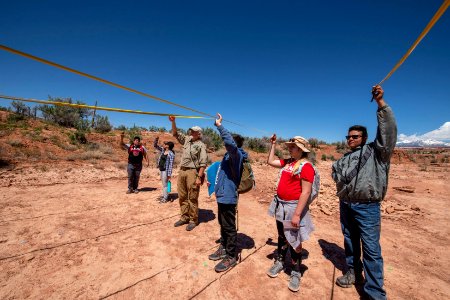 Taking measurements of a dino trackway near Moab UT. Photo by Eric Delphenich