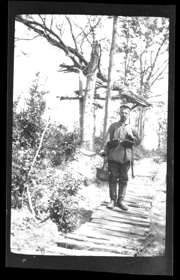 soldier in front of splintered tree