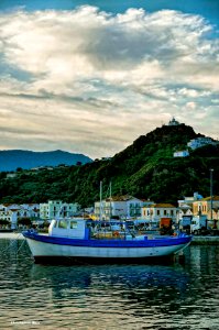 Karlovasi Port. Ayia Triada chapel on the hill in the font
