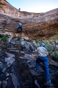BLM Paleontologist Dr. Greg McDonald helps the students rappel near the campsite. Moab, UT. Photo by Eric Delphenich