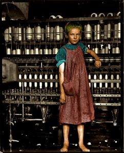 Child Labor: A barefoot girl works in a New England textile mill, 1910. (Colorized) photo