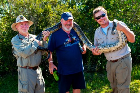 NPS Volunteer Wayne and Nick let Gaetan get up close and personal with an invasive python