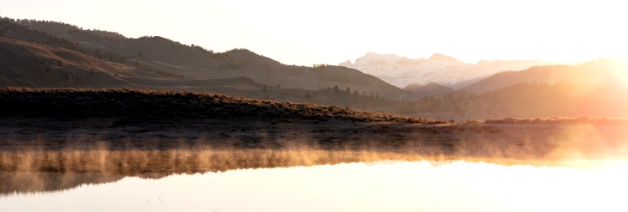 Steam from ephemeral ponds lit up at sunrise (panorama)