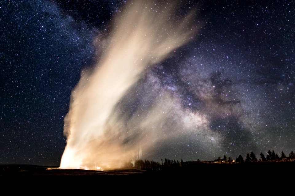 Old Faithful and Milky Way crisscross on a clear summer night