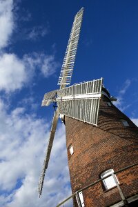 Restored windmill white sails red brick photo