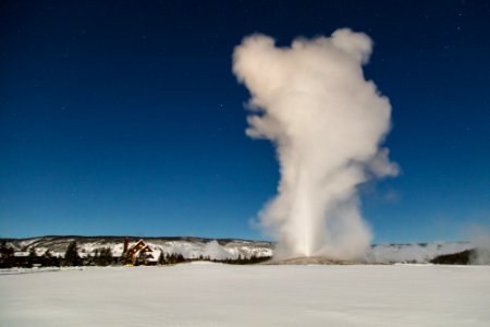 Old Faithful under a winter full moon photo