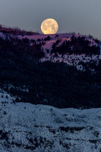 Full moon setting with morning alpenglow photo