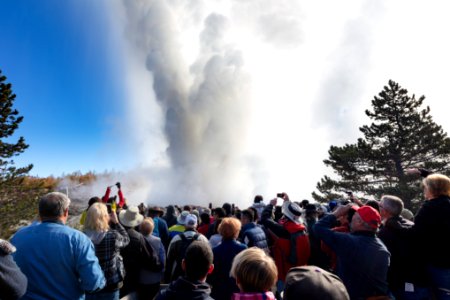 People watch and photograph a Steamboat Geyser eruption photo