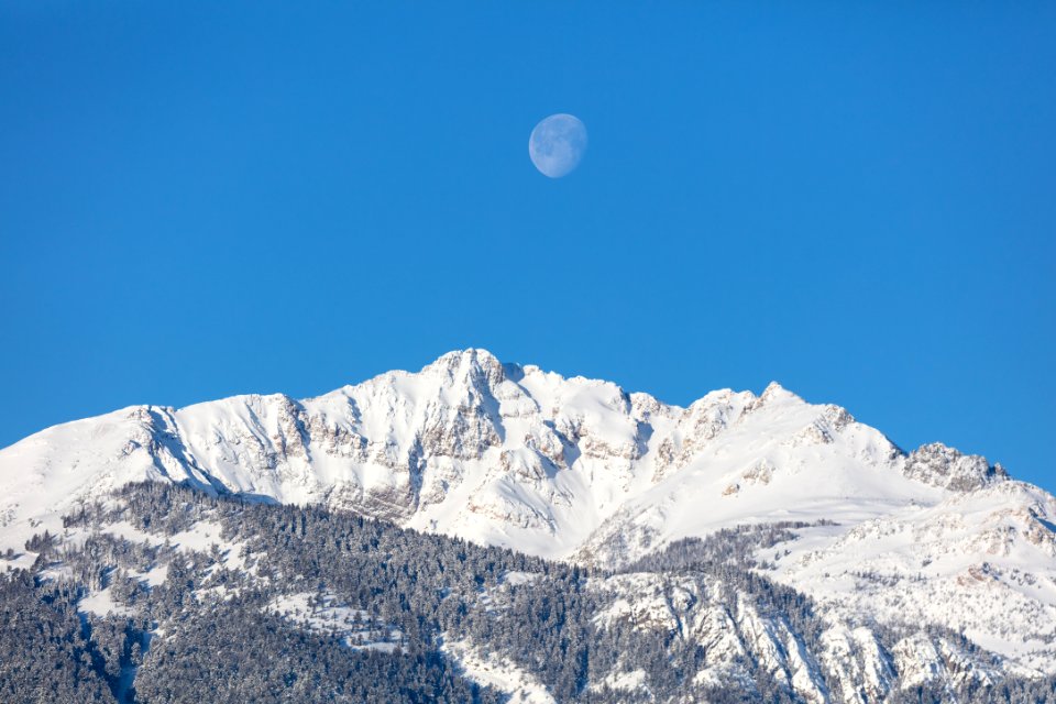 The moon above Electric peak after a winter storm