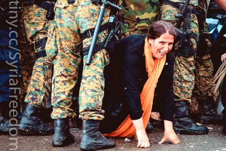 A woman cries as she crawls through a block of border police in the southern Macedonian town of Gevgelija, Sept. 10, 2015.