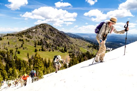 Hikers kicking steps up a steep snowfield