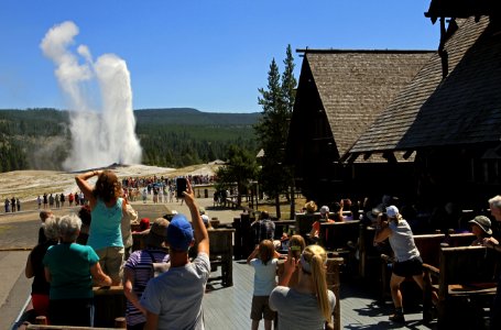 Old Faithful Inn, visitors watching an eruption of Old Faithful Geyser from the Inn's balcony