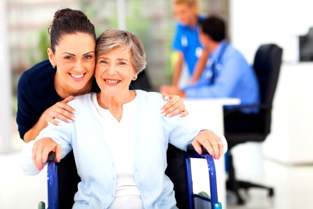 caring adult daughter accompanying senior mother visiting doctor photo