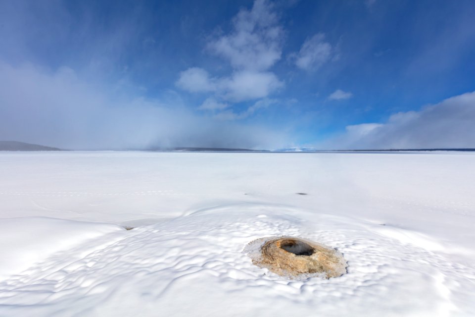 Big Cone Geyser rises out of a snowy landscape