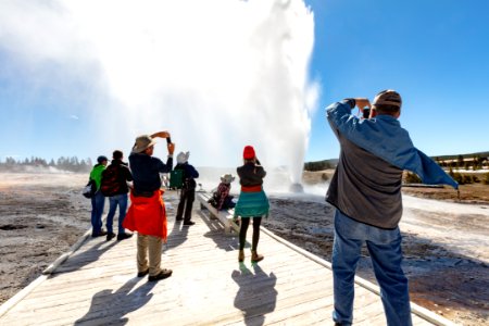 A group watches and photographs a Beehive Geyser eruption photo