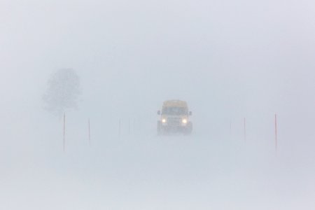 Snowcoach driving thorugh a blizzard past Lone Tree photo