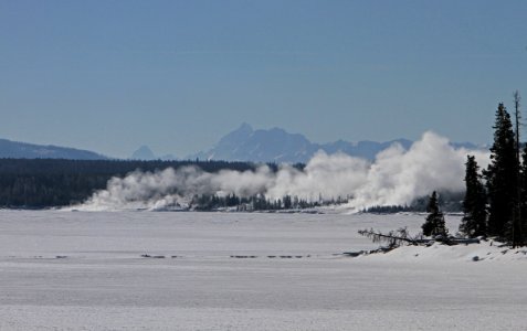 View across Yellowstone Lake to West Thumb Geyser Basin. Grand Teton Mountain Range 50 miles in the distance photo