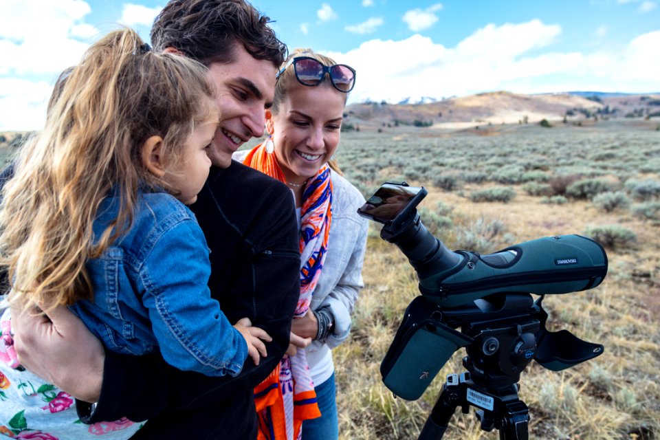 Family watching grizzly bears through a spotting scope