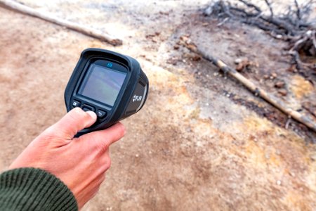 A thermal imaging camera shows increased temperatures under a trail in Norris Geyser Basin