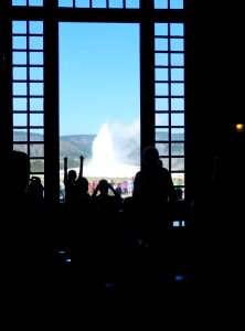 Old Faithful Lodge, a young visitor celebrating the start of an eruption of Old Faithful from inside the lobby