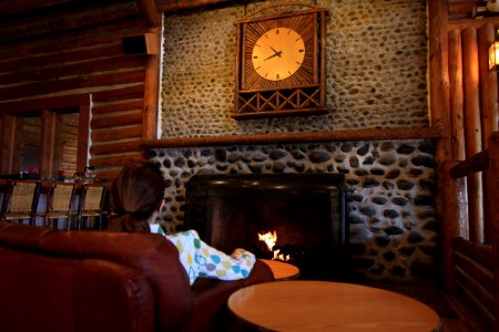 Lake Lodge, visitor sitting in lobby in front of fire place