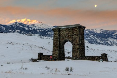 Full moon setting behind Roosevelt Arch and Electric Peak