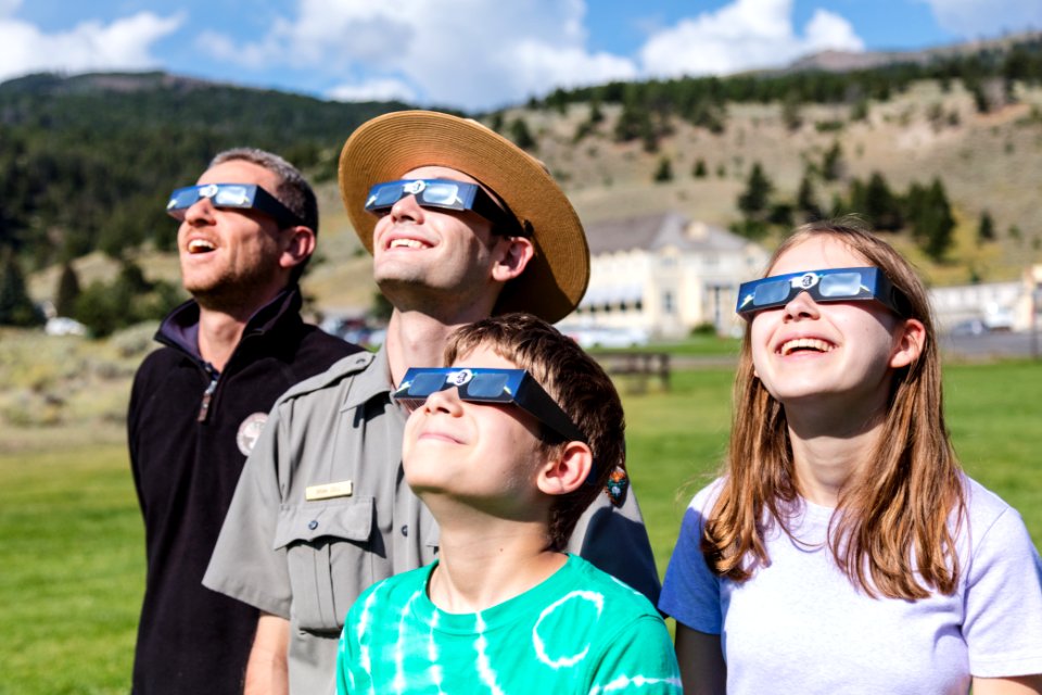 Ranger with a group viewing the sun with solar glasses