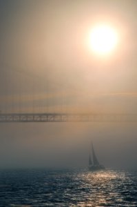 Lisbon, Tagus river, fog, mist, sea,golden hour, light, sun, sunset, bridge, sailboat photo
