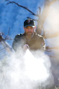 A ranger deploying bear spray (inert can)