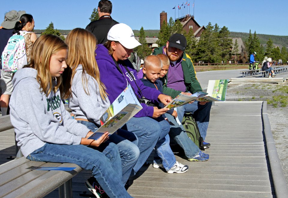 Family at Old Faithful working on Junior Ranger Program