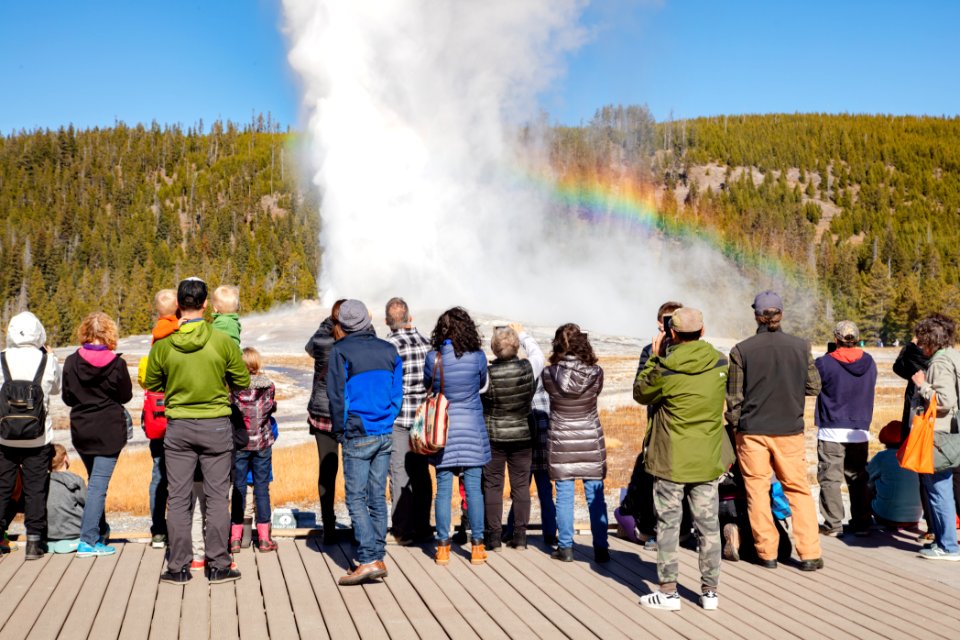 Old Faithful eruption and rainbow