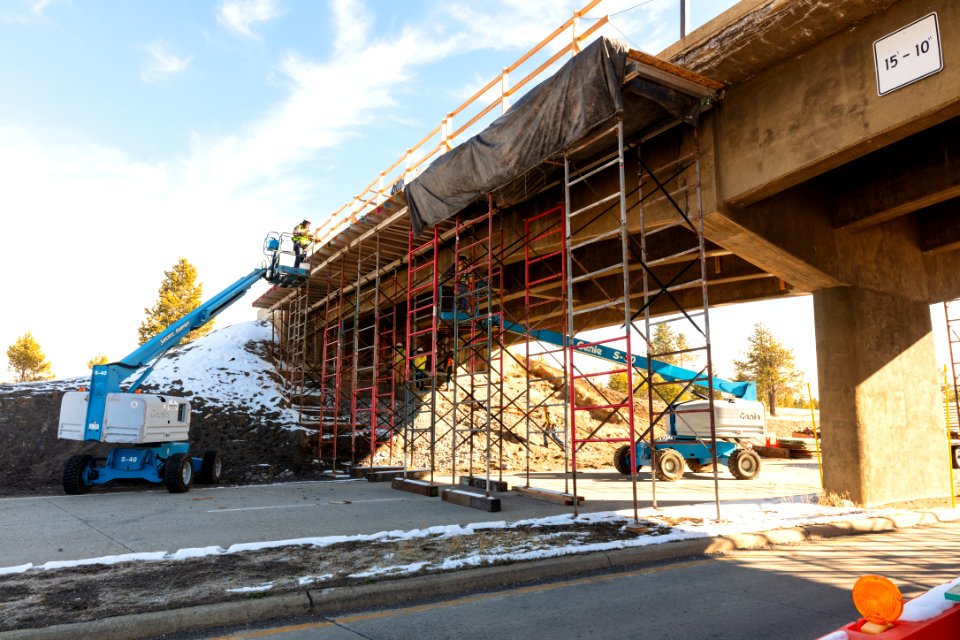 Old Faithful Overpass construction project: crews working on the railings