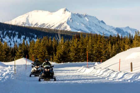 Snowmobilers with Electric Peak Backdrop photo
