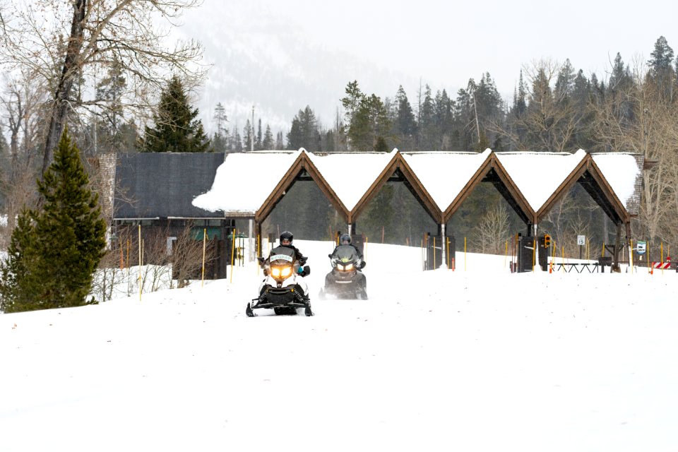 Non-commercial snowmobile group rides through the East Entrance