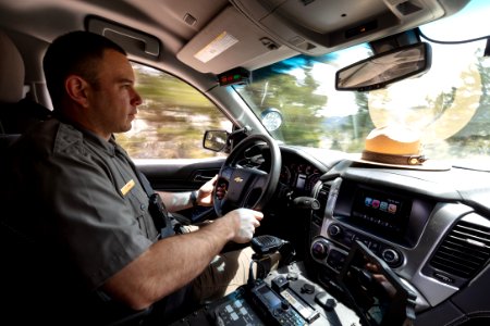 Ranger Stang driving in his patrol vehicle