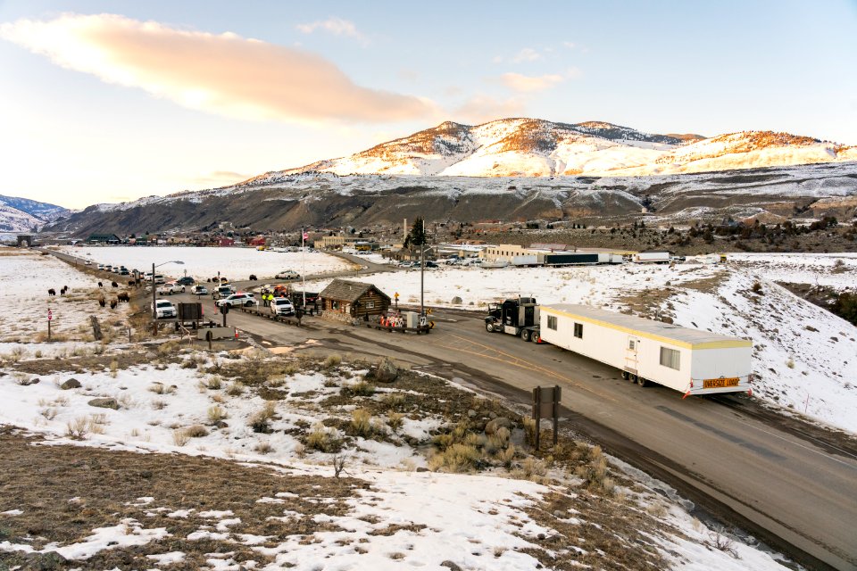 Outdated employee housing trailer being hauled out of the park through the North Entrance Station