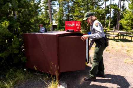 Ranger Sene checks a bear box for proper food storage
