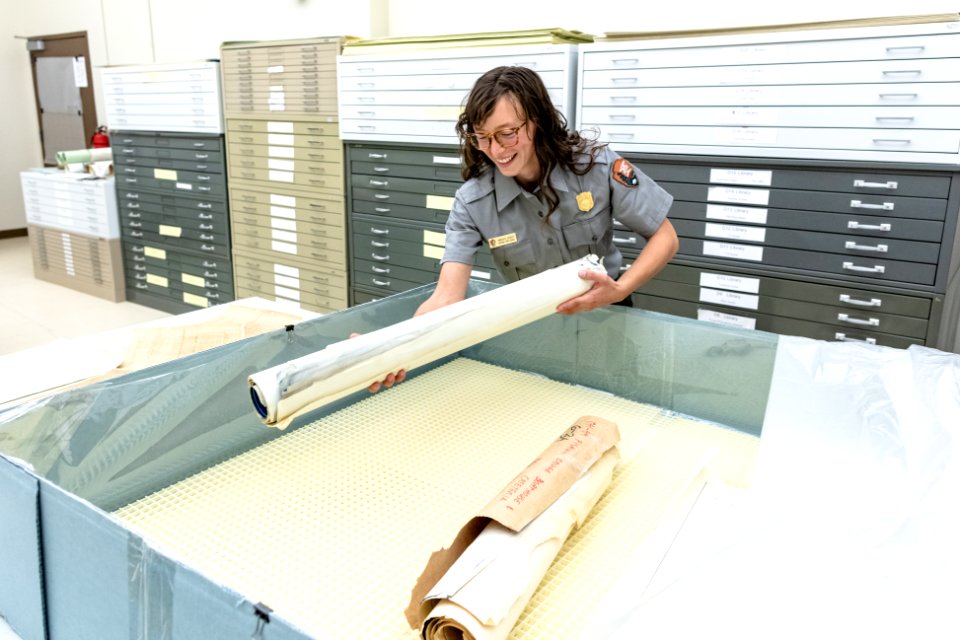 Kimberlee Roberts, Archives Technician, placing maps in the humidification chamber