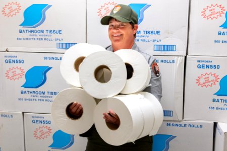 Facility Management & Operations employee Lisa in front of a stock of bathroom tissue photo