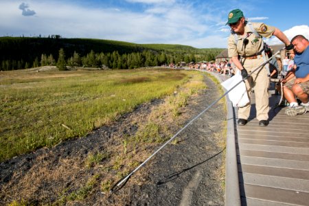 Volunteer picks up garbage near Old Faithful