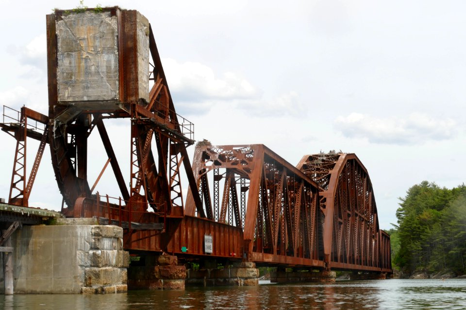 Rusty old rail bridge leading into the woods