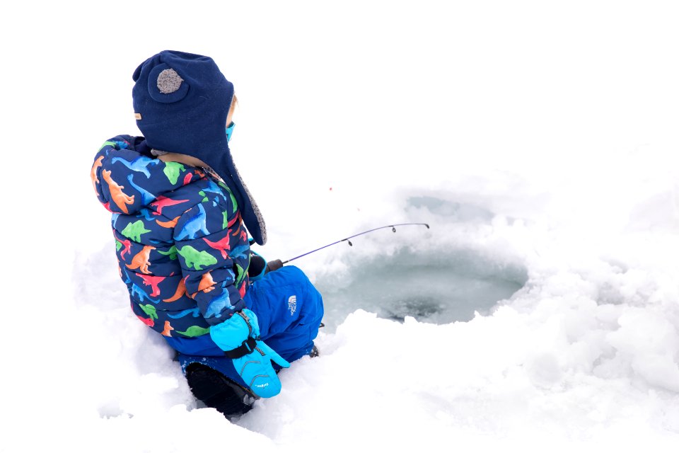 A small boy and family ice fishing.